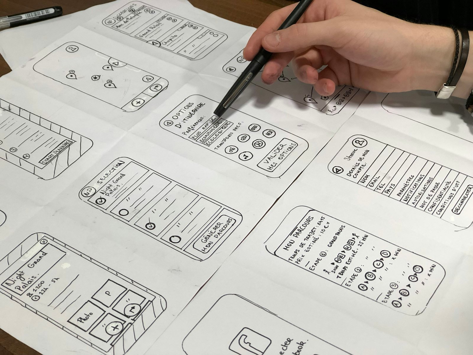 A designer sketching mobile app wireframes on paper